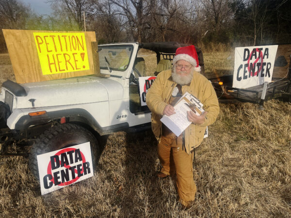 Allen Prather at the roadside petition drive he set up outside his home. The city of Coweta, Okla., is weighing a proposal to build a large data center adjacent to Prather’s property.