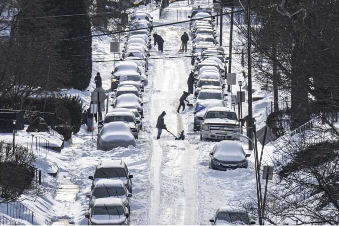 Residents shovel snow and dig out cars buried along a neighborhood street in Haverford Township, Pa., Monday.
