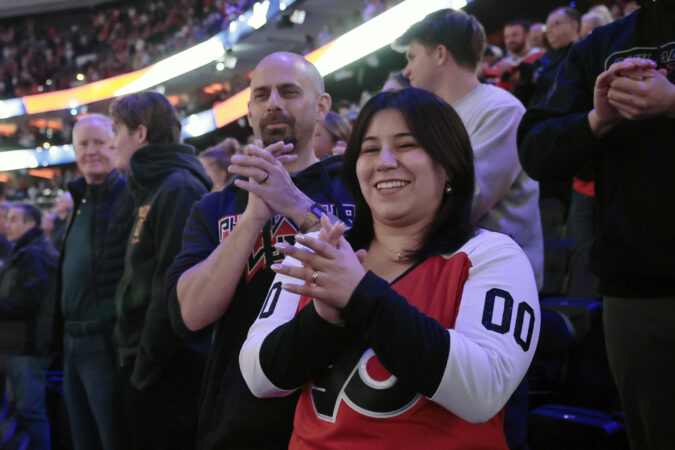 James, left, and Muriel Crescenzo applaud the National Anthem before Tuesday's Flyers-Capitals game.