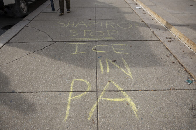 Chalk on the sidewalk reading “Shapiro Stop ICE in PA,” during a protest outside the Free Library as Gov. Josh Shapiro promoted his new book “Where We Keep The Light” in Philadelphia, Pa., on Saturday, Jan. 24, 2026.