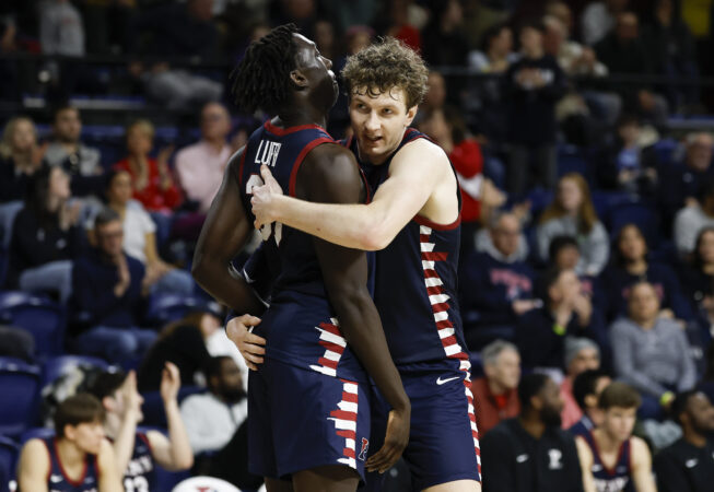 Penn forward TJ Power (right) and teammate forward Lucas Lueth celebrate their win over Cornell on Saturday.