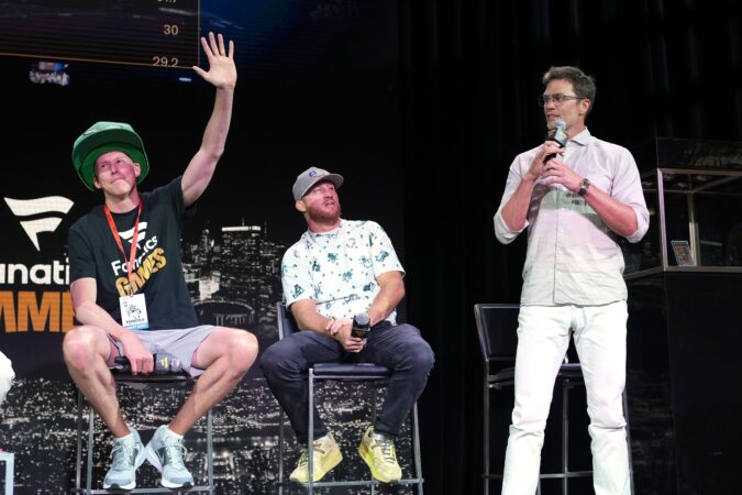 Pennsylvania high school teacher Matt Dennish (left) waves to the crows moments before Tom Brady (far, right) offered to buy the LeBron James rookie card Dennish won by placing third in last year's Fanatics Games.