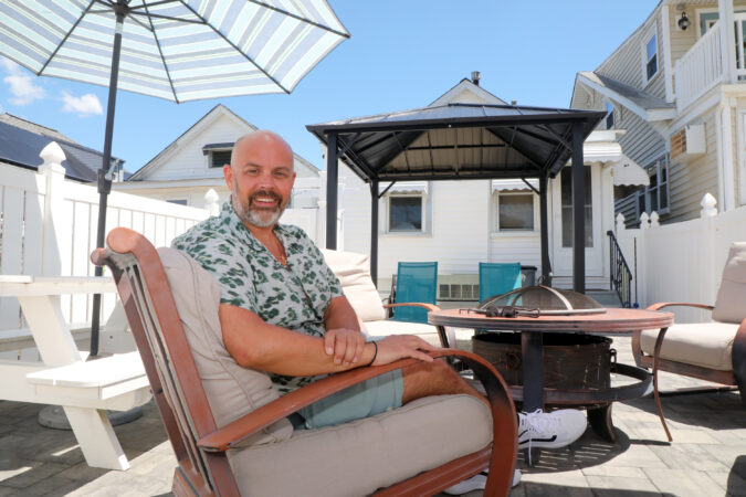 The backyard was made into an inviting space with fire pit, umbrellas, seating, and a pergola.