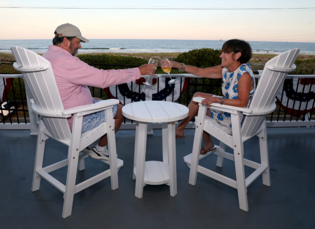 Katie and Randy Zakreski enjoy a glass of wine on their front porch, which faces the ocean at their home in Strathmere.