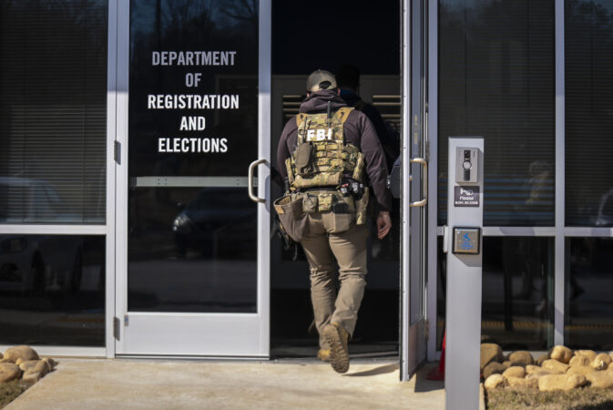 An FBI agent, part of a team executing a search warrant, enters the Fulton County Election Hub and Operation Center in Atlanta in January. For all of Donald Trump’s bluster about rigged elections, he remains the poster child for election interference, writes the Editorial Board.