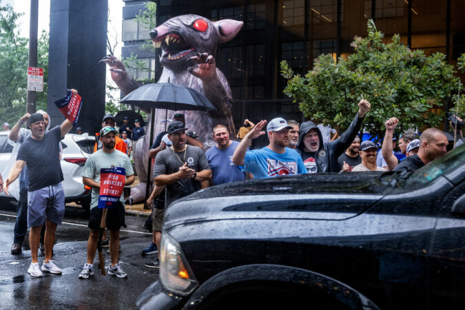 Striking Peco employees, part of IBEW Local 614, picket outside the company’s headquarters as one lane of traffic passes on Market Street Monday.