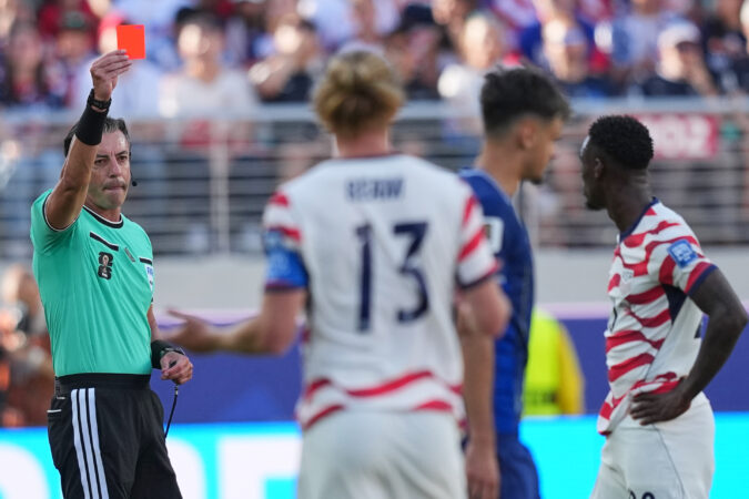 Referee Raphael Claus (left) showing the red card to Folarin Balogun.